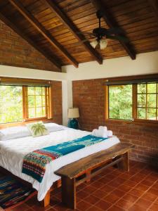 1 dormitorio con 1 cama grande y techo de madera en La Casa del Rio B&B, en Puyo