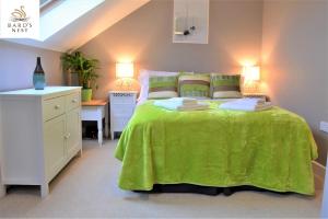 een slaapkamer met een groot groen bed en een bureau bij Bard's Nest, Crucible Apartment, FREE private parking, 3 mins walk to Birthplace in Stratford-upon-Avon