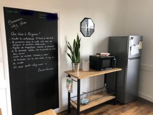 a black refrigerator and a table with a microwave at Chez Mumu in Périgueux