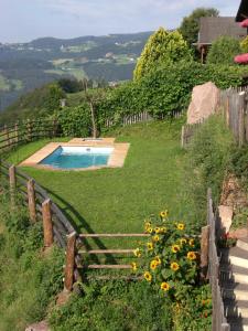 a yard with a fence and a swimming pool at Hofer Hof in Castelrotto