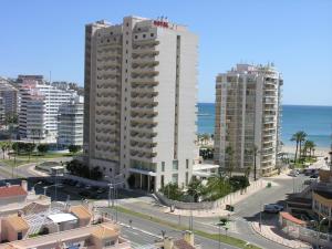 uma vista para uma cidade com edifícios e o oceano em Hotel Santamarta em Cullera