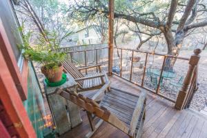 a porch with two wooden chairs and a potted plant at The Victorian Cottage at Creekside Camp & Cabins in Marble Falls