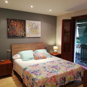 een slaapkamer met een bed en een schilderij aan de muur bij Apartamento Merceria - Tarragona in Tarragona