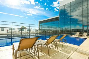 a balcony with chairs and a swimming pool on a building at TRYP By Wyndham Ribeirão Preto in Ribeirão Preto