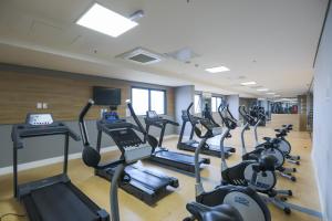 a gym with rows of treadmills and elliptical machines at TRYP By Wyndham Ribeirão Preto in Ribeirão Preto