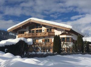 a house covered in snow with a fence at Apartment Streifblick in Reith bei Kitzbühel