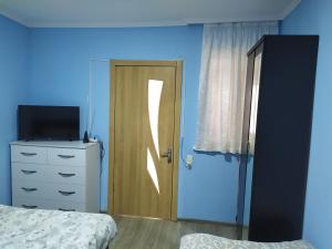 - une chambre avec une porte, un lit et une commode dans l'établissement Apartment LINIMA, à Tbilissi