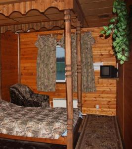 a bedroom with a bed in a log cabin at Tourist Complex Botik in Pereslavl-Zalesskiy