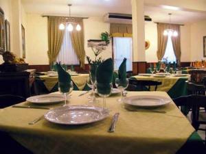 ビーゴにあるHotel Casablanca Vigoのテーブル(皿、ワイングラス付)