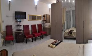 1 dormitorio y sala de estar con sillas rojas. en Appartamento Residence Canalotto en Realmonte