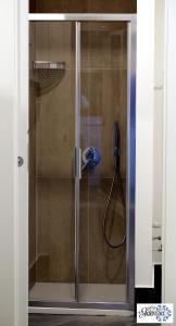 a shower with a glass door with a hose at B&B Adenzia in Caltanissetta