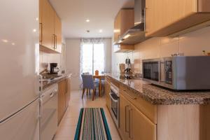 a large kitchen with wooden cabinets and a table at los granados 1221 in Manilva