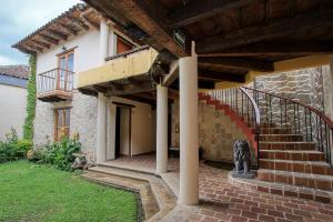 a stone house with a staircase in a yard at Hotel San Marcos in San Cristóbal de Las Casas