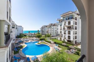 uma vista para uma piscina a partir de uma varanda de um edifício em marina duquesa 519 em Manilva