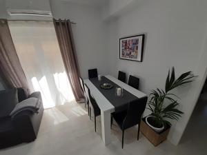 a dining room with a table and chairs and a plant at Domotic Lux Apartment in Granada