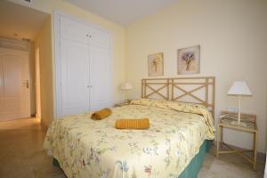 a bedroom with a large bed with a yellow blanket at marina duquesa 616 in Manilva +19 photos