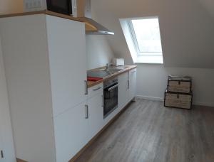 a kitchen with white cabinets and a sink and a window at Wohlfühlquartier Louisenlust in Eutin