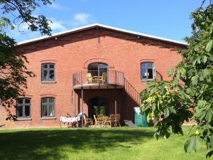 a brick building with a balcony and tables and chairs at Apartments Lille Hus in Sankt Peter-Ording