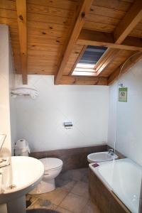 a bathroom with a toilet and a tub and a sink at Apartamentos Cuevas del Mar in Nueva de Llanes