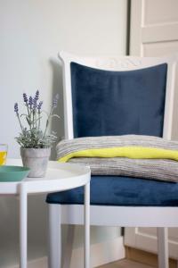 a blue chair sitting next to a table with a potted plant at Nana / Sobe & Apartmani in Valjevo