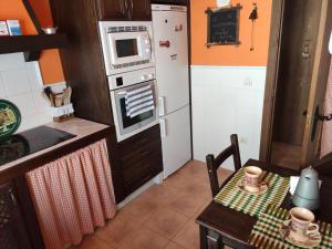 a small kitchen with a table and a microwave at VUT Casa Helen in Ávila