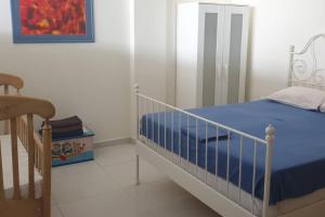 Schlafzimmer mit einem Bett mit blauer Decke in der Unterkunft Bright, Spacious, Elegant, semi Subterrain with Garden, 5min from sea in Kalamata