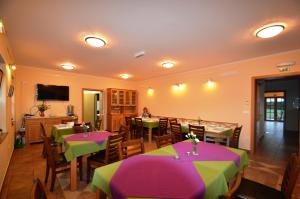 Hostel Strug في Makole: مطعم به طاولات مع مفارش مائدة خضراء وأرجوانية