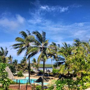 a view of a resort with a pool and palm trees at Ocean Sports Resort in Watamu
