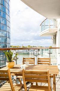 倫敦的住宿－Riverside Balcony Apartments, 10 minutes from Oxford Circus，阳台的天井配有木桌和椅子
