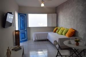 a bedroom with a bed and a table and a tv at Flat Vila Aju in Aracaju