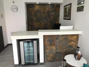 a reception desk in a room with a stone wall at HOTEL ZARCILLEJO in Pasto