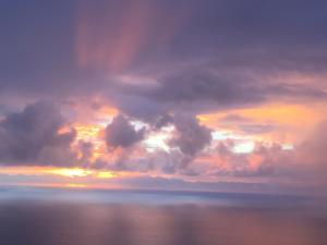 a sunset over the ocean with clouds and water at Serenity Hale in Papa Bay Estates