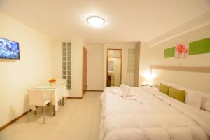 a bedroom with a large white bed and a table at Wayta Inn in Cusco