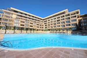 a large swimming pool in front of a building at Menada Luxor Apartments in Sveti Vlas