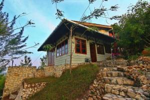 ein kleines Haus auf einer Steinmauer in der Unterkunft Fam Sugiono Cottage - Studio House in Kemadang + 25 Fotos