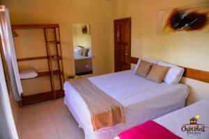 Un dormitorio con dos camas y un espejo. en Chocolat Barra Beach, en Maraú 15 fotos más