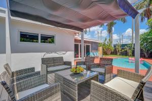 a patio with chairs and a table and a pool at Elegant Tropical House with Pool in Hollywood