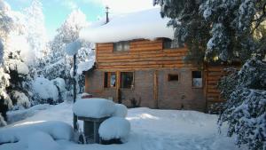 a log cabin with snow on the roof at EL Arka in San Carlos de Bariloche