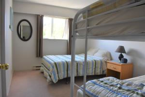 a bedroom with two bunk beds and a mirror at North Coast Trail Backpackers Ltd in Port Hardy