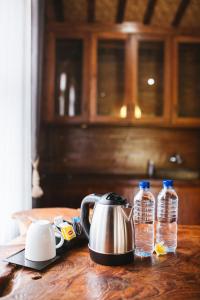a tea kettle and two bottles of water on a table at Baligong Villa in Sukawati