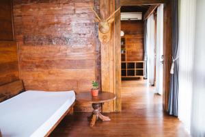 ein Schlafzimmer mit einem Bett und einem Tisch in einem Zimmer in der Unterkunft Baligong Villa in Sukawati