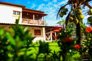 una casa frente a un patio con flores en Chocolat Barra Beach, en Maraú