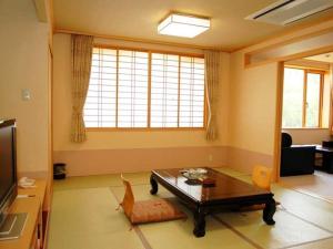 
a living room filled with furniture and a tv at Yunokaku Ikedaya in Teshikaga

