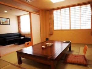 
a living room filled with furniture and a window at Yunokaku Ikedaya in Teshikaga
