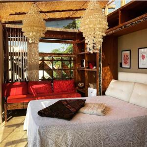 a bedroom with a bed and a couch and chandeliers at Mansion Aline in Rio de Janeiro +43 photos