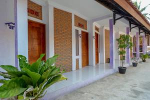 a building with plants in front of it at RedDoorz near Goa Jatijajar 2 in Kebumen