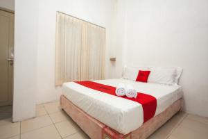 ein Schlafzimmer mit einem Bett mit zwei Handtüchern darauf in der Unterkunft RedDoorz near Taman Bungkul in Surabaya