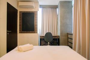 ein Schlafzimmer mit einem Bett, einem Schreibtisch und einem Stuhl in der Unterkunft Homey 1BR at 15th Floor Apartment at Atlanta Residences By Travelio in Depok
