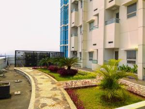 ein Garten vor einem Gebäude in der Unterkunft Homey 1BR at 15th Floor Apartment at Atlanta Residences By Travelio in Depok