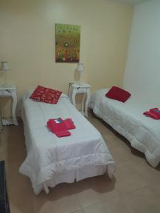 2 Betten in einem Zimmer mit roten Handtüchern darauf in der Unterkunft Laguna Esmeralda B&B in Ushuaia